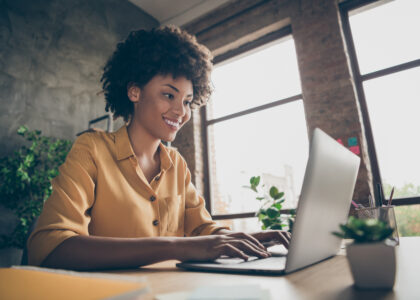 Photo of smiling African-American business woman at computer